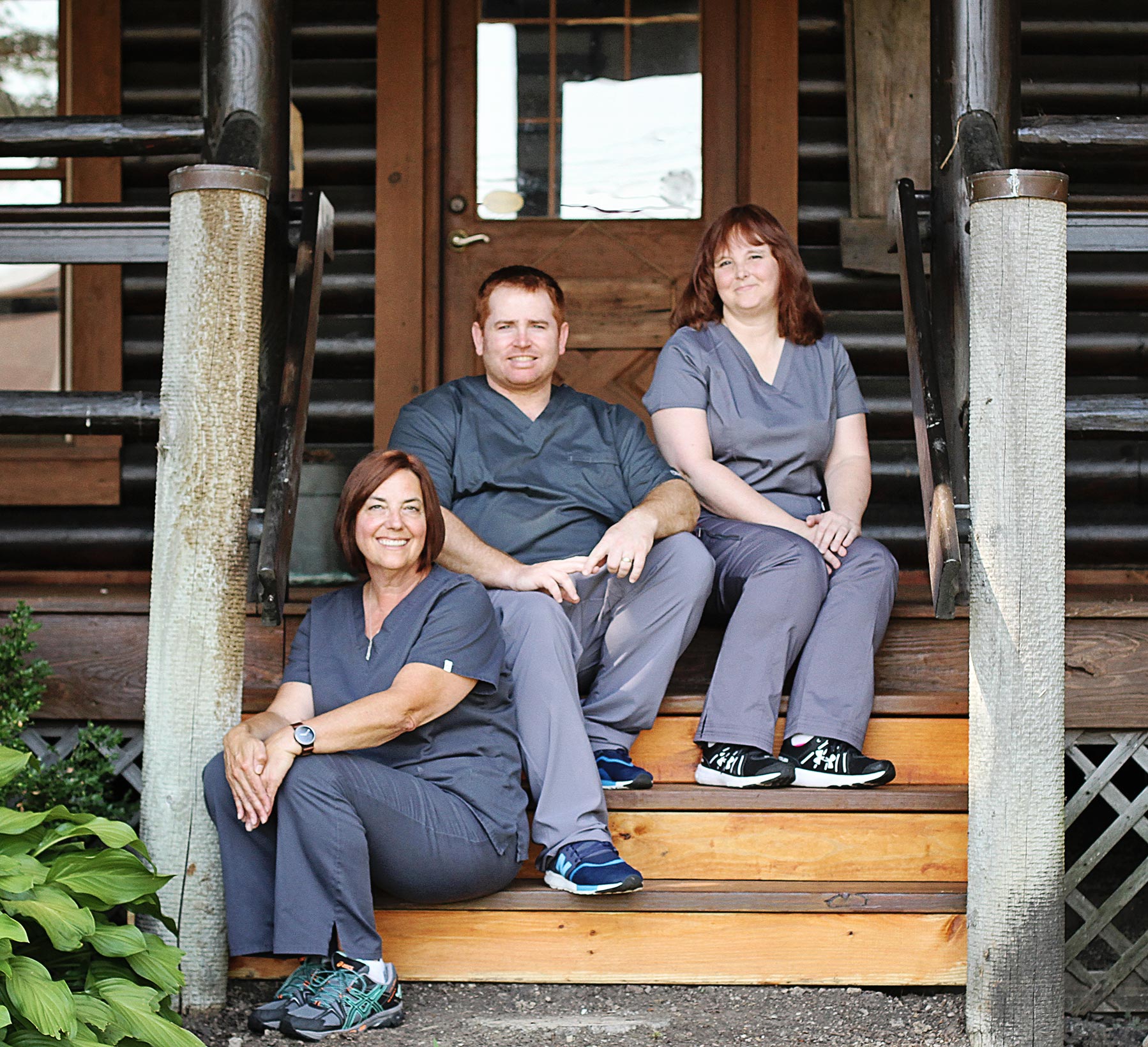 Dr. Kanetsky smiling in front of cabin with his staff